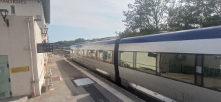 Train de la Côte Bleue stationné en gare de Martigues et en direction de Marseille par la Côte Bleue. Le train est gris et bleu, c'est un TER. Un écriteau indique le nom de la gare ferroviaire