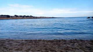 Photo d'une plage de sable prise au bord de l'eau avec le remous des vagues. La luminosité de l'image laisse penser qu'elle a été prise en fin de journée