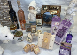 Penser à vos cadeaux de Noël avec des produits originaux à petits prix - © Otmartigues / MelindaC Des produits sont posés sur une table décorée pour Noël avec ange et sapin. Savons de la marque Marius Fabre, bouteilles de vins locaux, pochons de lavande et senteurs de la marque Esprit Provence, jeu de société Circino