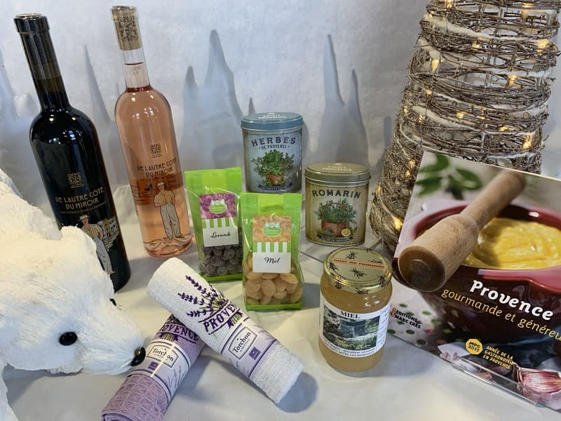Mise en avant de produits aux couleurs de lrégion. Torchons brodés de lavande, miels et bonbons locaux, boîtes d'herbes de Provence et vins de la cave coopérative