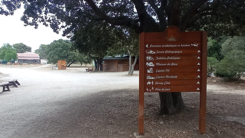 Am Eingang zum Park Figuerolles befinden sich Informationstafeln mit Hinweisschildern zum Baumwipfelpfad, dem Streichelzoo und den familienfreundlichen Spazierwegen im Park.