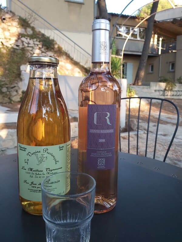 Bottles of wine and fruit juice produced by the Saint-Julien-les-Martigues winery. Bottles placed on a wrought iron table typical of Provence - © Otmartigues - VictoriaG