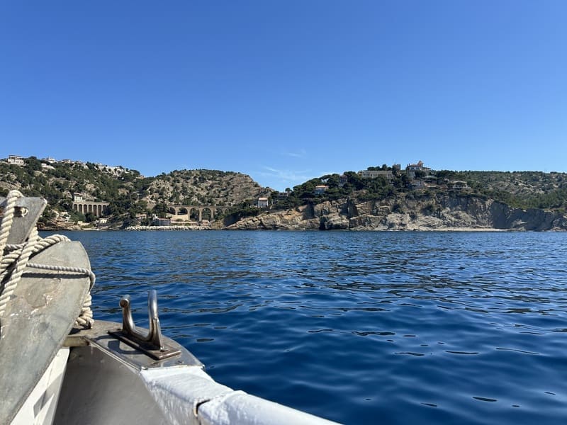 View of the Côte Bleue cliffs and the Port of Niolon from the boat departing from Martigues. The bow of the boat is visible in the foreground of the photo - © Otmartigues / MelissaE