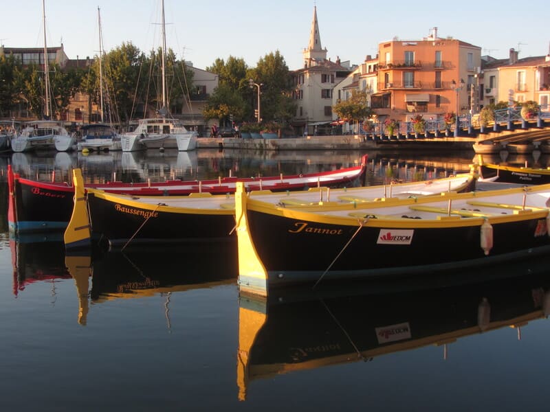 Venetian rowers' boats in the colors of Martigues: red and yellow. A traditional rowing sport in the canals of Martigues by the Martigues Venetian Rowers Association. The boats are - © Otmartigues / KarimK