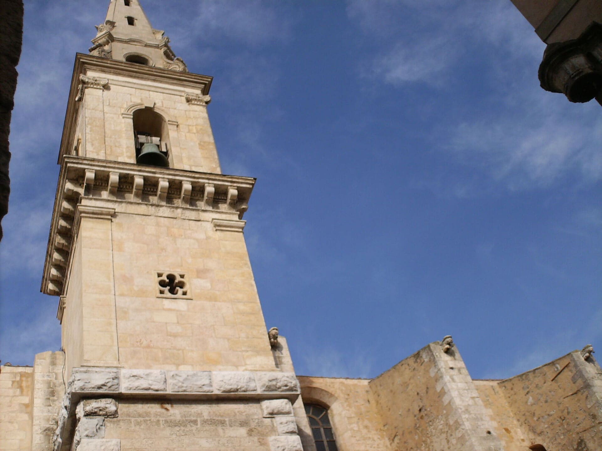 Bell tower of the Chapel of the Annunciation and its architectural details. The bell is visible; the ramparts on the right side of the photo reveal a small window. - © Otmartigues / MyriamF