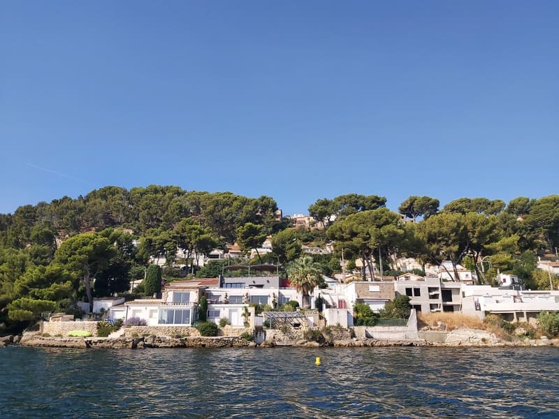 Maisons habitées sur les rives de l'étang de Berre au coeur de la nature sauvage avec des pins en arrière plan - © Otmartigues - VictoriaG