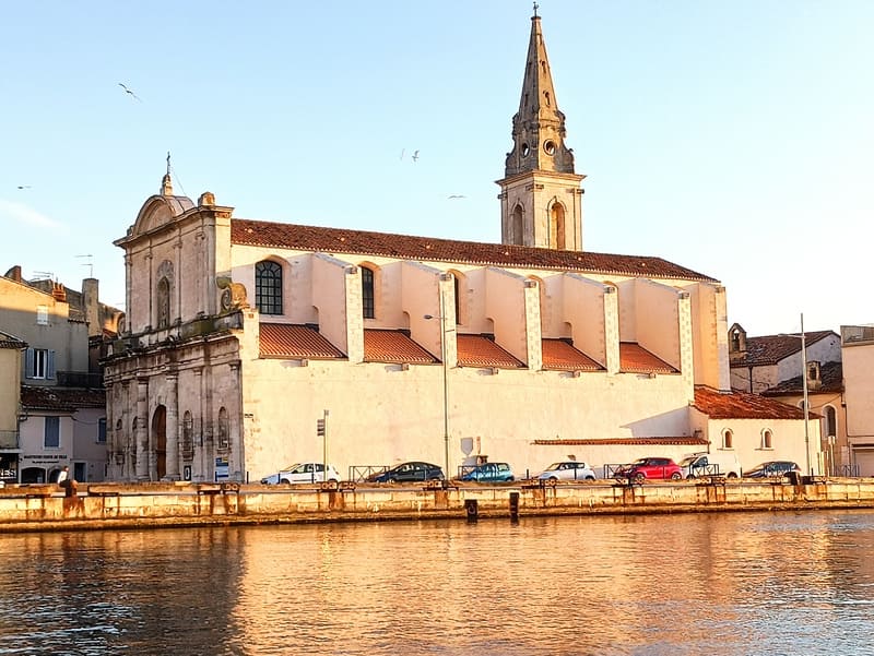 Église de Saint-Genest et sa façade blanche rénovée. Prise depuis le pont levant de l'autre côté du canal de Martigues. Edifice religieux en hommage à Gérard Tenque - © Otmartigues / KarimK