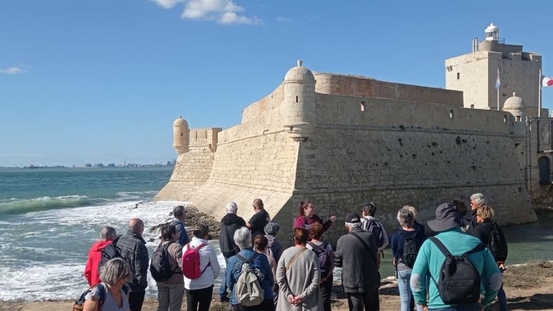 Participants in the tour of Fort de Bouc organized by the Martigues Tourist Office. From the shore, the imposing building towers with its walls and fortifications. - © Otmartigues / MyriamF
