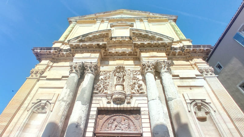 Vue en contre plongée de l'église de la Madeleine sur le quartier de l'Ile à Martigues. Les détails baroque de la façade blanche et sa grande porte en bois la rend majestueuse - © Otmartigues / MyriamF