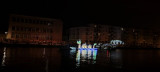 The surroundings are dark, and a luminous float occupies the entire space. It represents a monster from the Étang de Berre, like a dragon. It parades on the water of the Martigues 