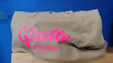 Khaki green cavas bag with pink writing including the humorous quote Girelles où tu iras from the Galinettes brand highlights the characteristics of the Côte Bleue
