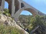 La photo est prise au pied du pont ferroviaire de Carry-le-Rouet. La végétation est visible. La roche de la calanque est rude. C'est un beau paysage de la Côte Bleue