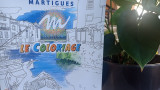 Couverture du carnet de coloriage posée à côté d'une plante, présentant un design attrayant.