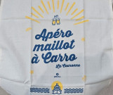 Paño de cocina beige, azul y amarillo con la inscripción Apéro maillot en Carro en Martigues ofrecido por el diseñador local Galinettes. En referencia a la Côte Bleue