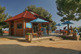 Bâtiment de l'accueil de Camping Paradis avec parasol bleu
