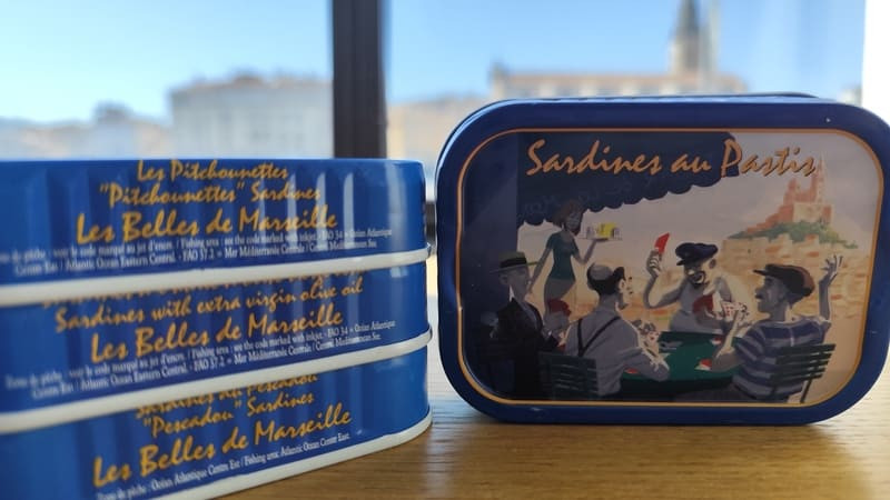 Dose Sardinen mit Pastis von Ferrigno in Port-Saint-Louis-du-Rhône. Die Vitrine zeigt Kartenspieler an der Bar unter Platanen – das schöne Leben in der Provence.