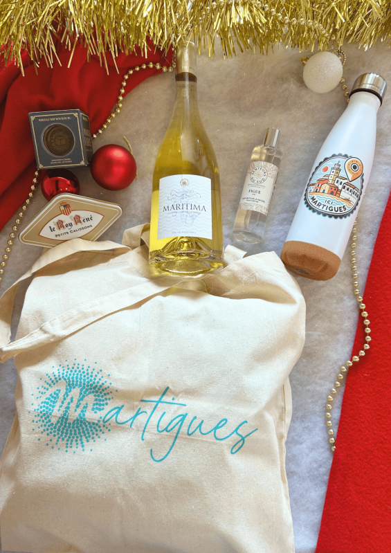 Christmas gift set is available at the Martigues Tourist Office shop with a bottle of white wine - © Otmartigues / PaolaM A Christmas gift set is available at the Martigues Tourist Office, including a Martigues tote bag and water bottle, a bottle of Maritima white wine, a Marius Fabre soap, a box of Roy René calissons, a