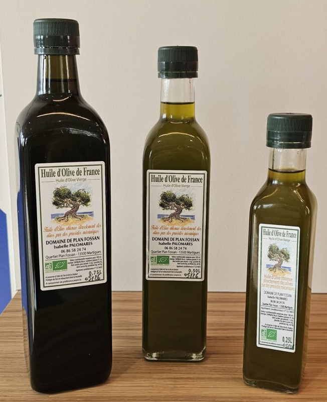 Three green bottles with a label mentioning olive oil from Domaine de Plan Fossan in Martigues. The 75cl bottle is organic and bears the AB logo