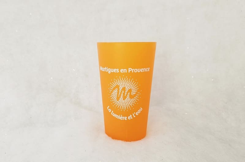 Vaso naranja con las palabras Martigues en Provence y la M de Martigues. Un vaso práctico para picnics y para disfrutar de la playa.