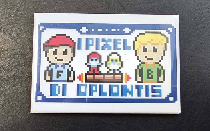 Ein Magnet mit den beiden Schöpfern des Mobile Games „I Pixel Di Oplontis“, einem Mosaik-Suchspiel in der Innenstadt von Martigues. Erhältlich im Shop der Touristinformation Martigues.