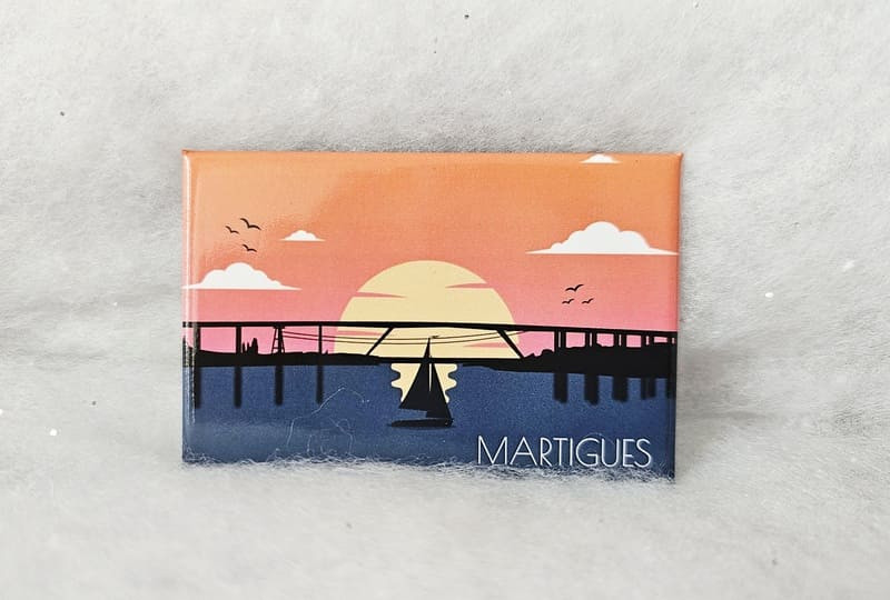 Illustrierter Magnet mit dem Sonnenuntergang über dem Mittelmeer unterhalb des Autobahnviadukts am Ortseingang von Martigues. Ein wunderschöner Magnet, erhältlich im Fremdenverkehrsamt von Martigues.