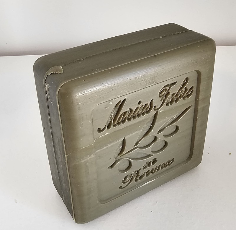 Marius Fabre - Green Marseille soap 150gr - © Otmartigues / SergeT 150g Marius Fabre green Marseille soap viewed from above outside its packaging, featuring the inscription 'Marius Fabre Provence' and an olive branch in the background