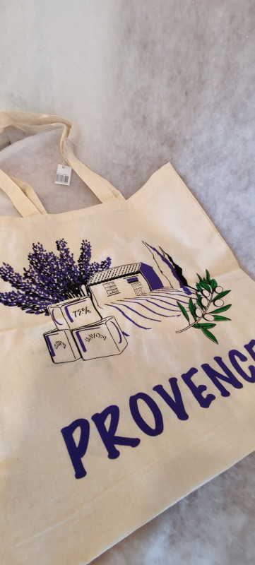Tote bag beige con un diseño en púrpura que representa ramitas de lavanda, un campo de lavanda y un jabón de Marsella, con la inscripción 'Provence' en verde para las hojas