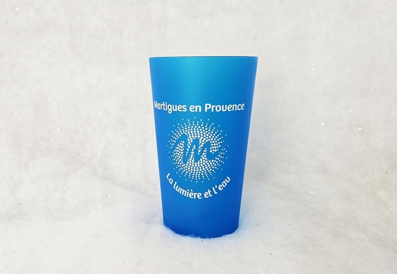 Sky blue cup with the words Martigues en Provence and the letter M for Martigues. A practical cup for picnics and swimming at the beach.