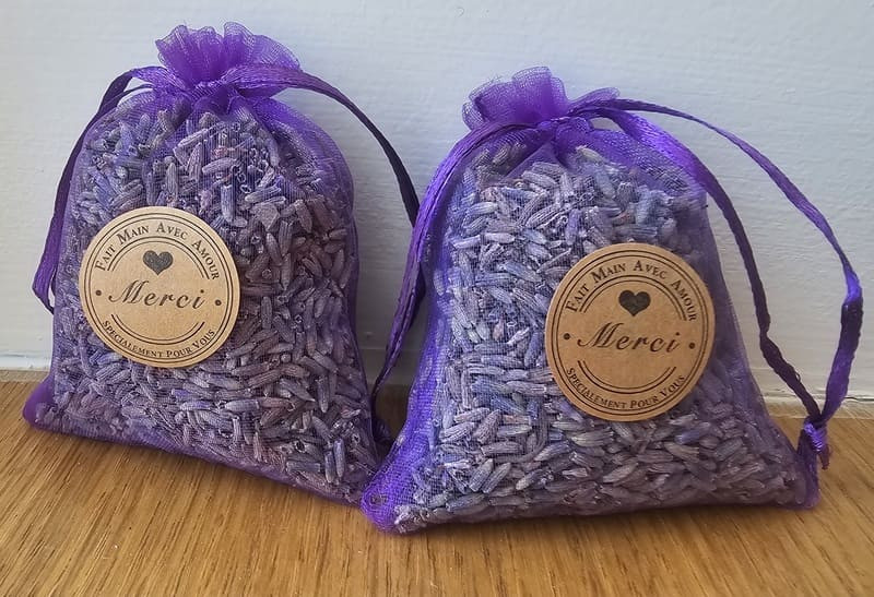 Deux sachets de lavandin de couleur violet et transparent pour laisser apparaître le grain de lavande. Une étiquette Merci est disposé au centre, fait main avec amour