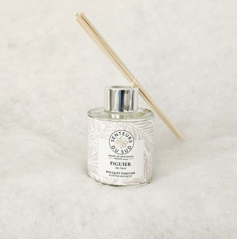 Ramo aromático con tallos de madera en la parte superior. Una elegante etiqueta gris con motivos de hojas adorna el recipiente de vidrio. La marca y la fragancia de Senteurs du Sud están claramente in - © Otmartigues / MarianneB Ramo aromático con aroma a higo, creado por Senteurs du Sud. Una original mezcla de fragancias provenzales disponible en la Oficina de Turismo de Martigues.