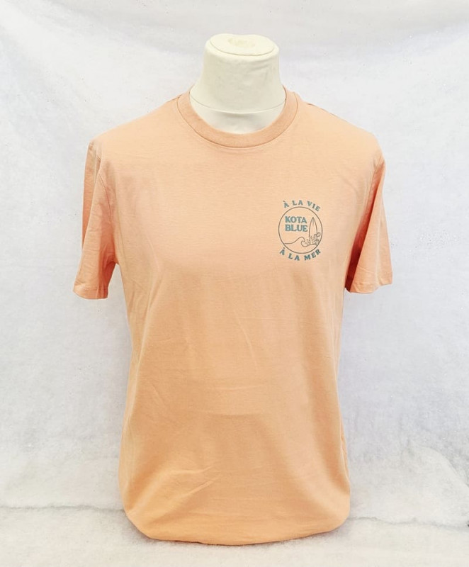 Tee-shirt couleur pêche avec écritures bleu de la marque Kota Blue situé sur la Côte Bleue, côté Martigues. Article en vente à l'Office de Tourisme de Martigues