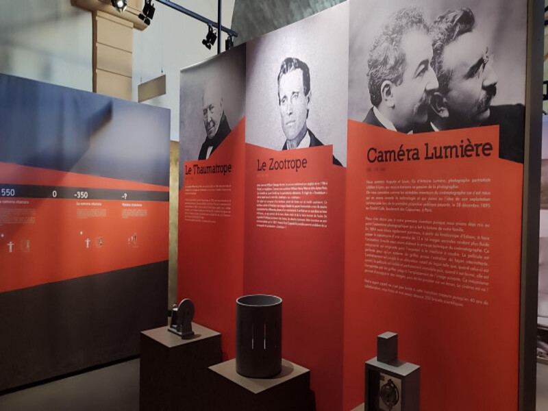 Panel informativo en la Cinemateca Gnidzaz que recorre la historia del cine en Martigues. Objetos de colección expuestos en primer plano.