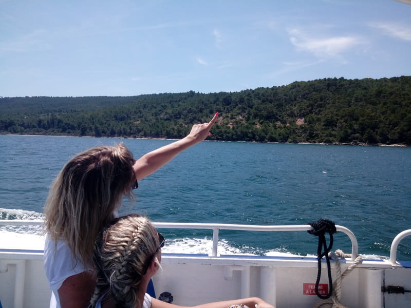Deux jeunes femmes de dos participent à la balade en bateau sur l'étang de Berre depuis Martigues et regardent le paysage sauvage qui caractérise les rives de l'étang - © Otmartigues - VictoriaG