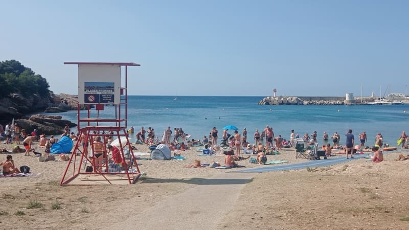 Carro Beach, between pebbles and sand, with a lifeguard station for beach lifeguards in Martigues. Tourists are relaxing on the sand; the sea is calm. - © Otmartigues / MyriamF