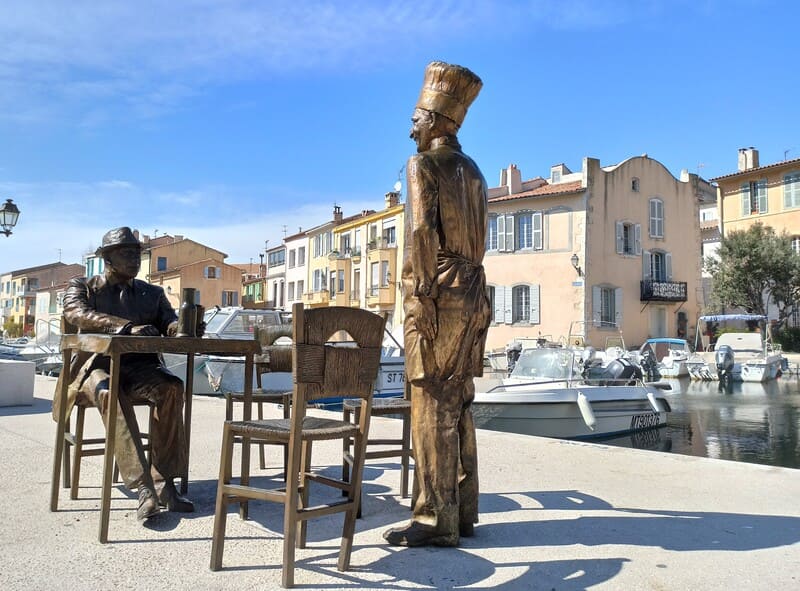 Statues en bronze des acteurs Bourvil et Fernandel dans le film La Cuisine au Beurre tourné à Martigues. Statues devant la maison en Chapeau de Gendarme servi de décor pour le film. Possible de prendre des photos pour les touristes - © Otmartigues / KarimK