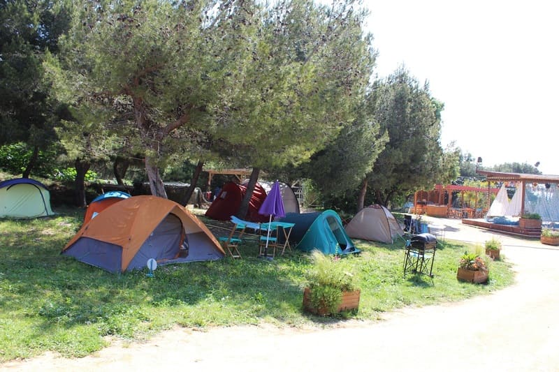 Tentes de camping aménagées dans les allées du tournage de la série Camping Paradis. Les tentes sont installées dans l'herbe comme si elles étaient en pleine nature et isolées  - © Otmartigues / ElodieM