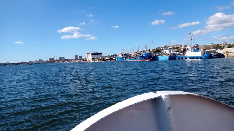 Calm sea and the bow of the boat visible in the foreground approaching the Calen de Martigues. Boat heading to Fort de Bouc for a guided tour with the Martigues Tourist Office - © Otmartigues / MyriamF